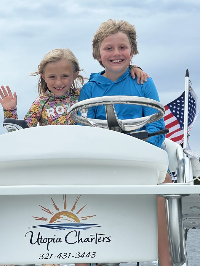 Two young guests at the helm of Utopia, Cocoa Beach